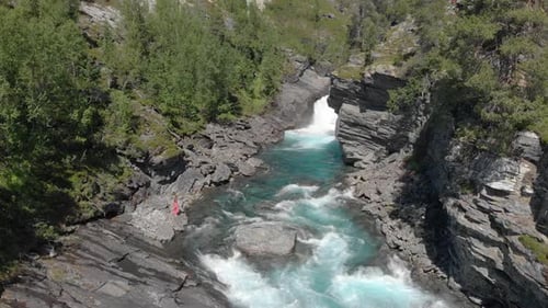 The powerful mountain river and breakable girl walking beside