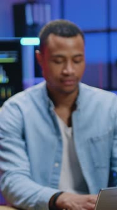 Young Adult Man Smiling at Desk in Office
