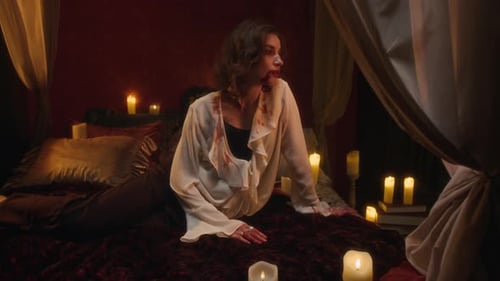 Portrait of Blood-Stained and Smiling Vampire Woman on Dark Red Bed