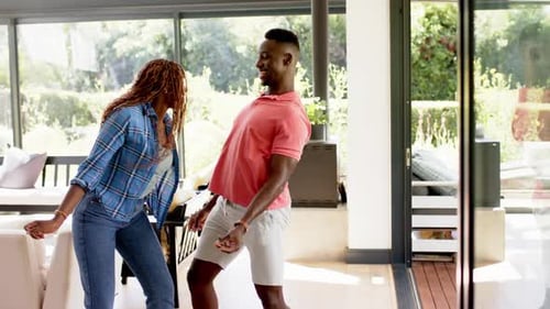 Happy Couple Dancing Together in Bright Home