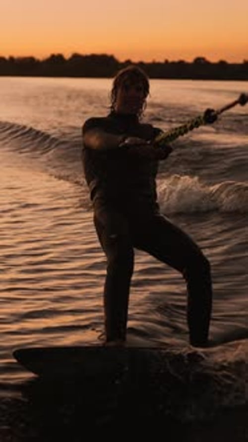 Man wakeboarding on the lake at sunset