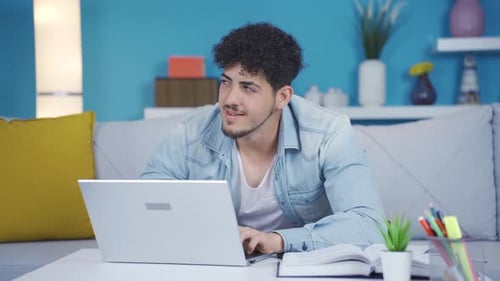 Happy young man chatting on computer.