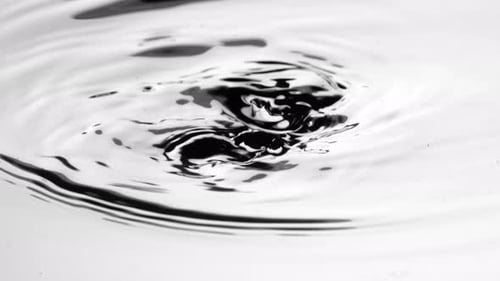 An Underwater View of a Dark Hand Scooping Up Handful of Water and Dripping Onto Surface