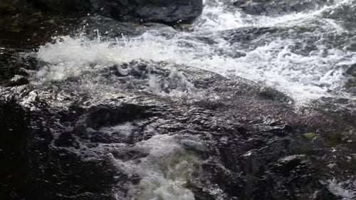 Wildwasser plätschert über Felsen in schnell fließendem Fluss - Zeitlupe