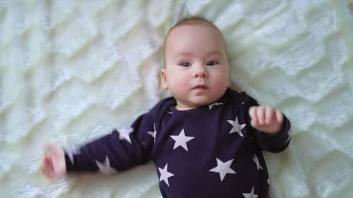Cute small newborn boy. Gorgeous little baby lies on the bed.