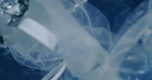 Contaminated water filled with old plastic and rubbish floating around. Close up.