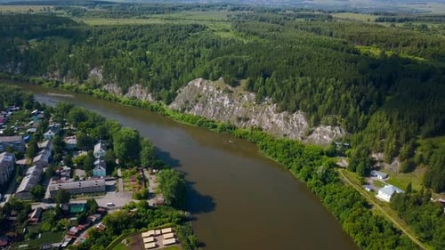 Small village with houses located near green forest