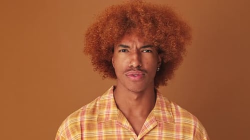 Close up, guy with big eyes, says wow looking at the camera isolated on brown background in studio