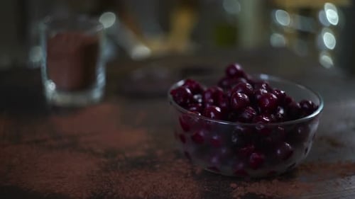 Cherries, chocolate, and cocoa powder on table