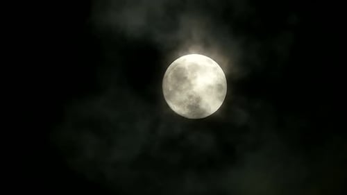 Der Vollmond scheint hell am bewölkten Nachthimmel und bildet eine mystische Kulisse