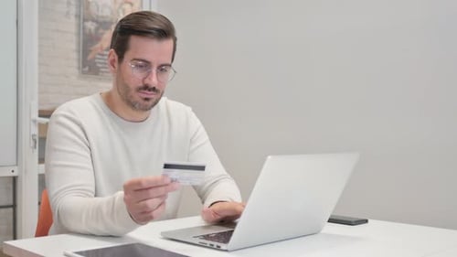 Happy Middle Aged Man Shopping Online on Laptop in Office