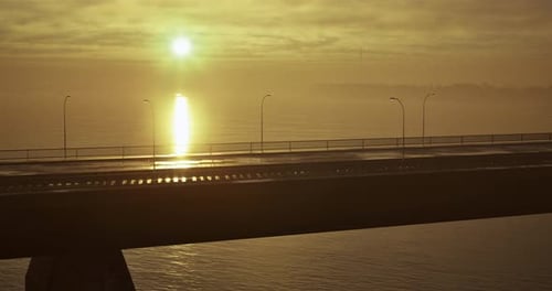 Stunning Sunrise Over Waterfront Bridge with Shimmering Reflections on Water