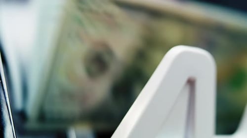 Primer plano de la máquina contadora de dinero que cuenta billetes de cien dólares