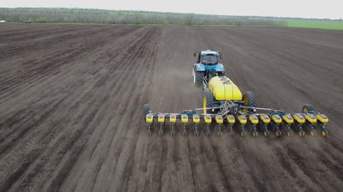 Blue tractor OA working on the field in Ukraine