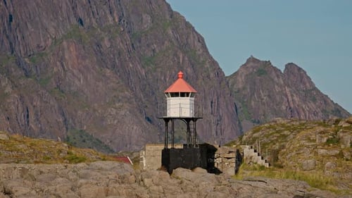 Lighthouse Standing Tall Against Rugged Mountain