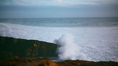 Powerful ocean waves crashing on rocky shoreline volcano beach in dramatic seascape