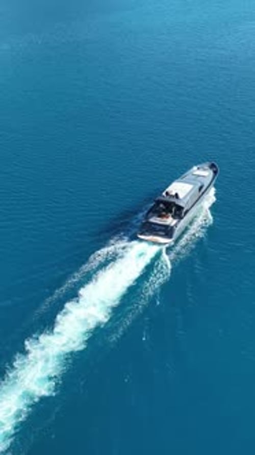 Sleek Vessel's Voyage: An aerial view captures a sleek, luxurious yacht gracefully navigating the en