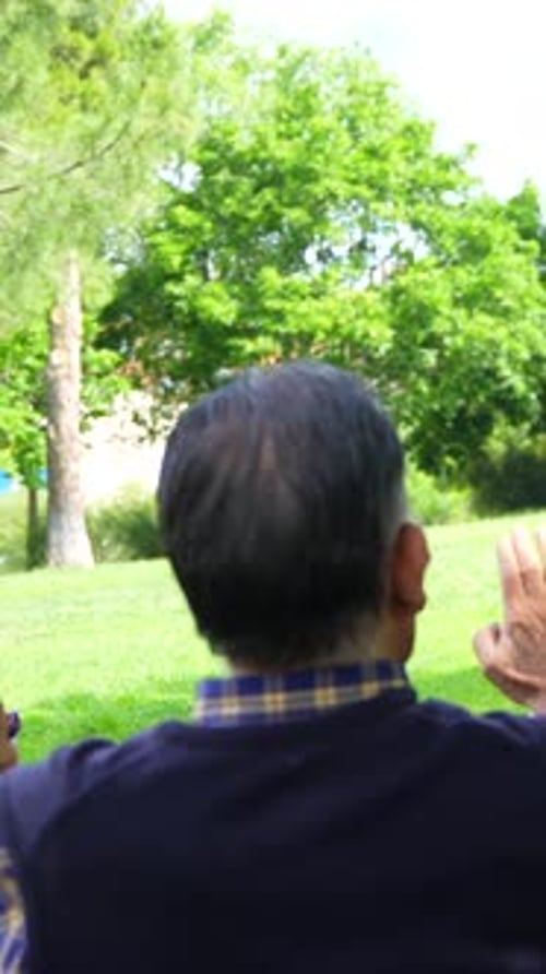 An elderly woman with the nurse on a walk through the garden of a nursing home in a wheelchair and g