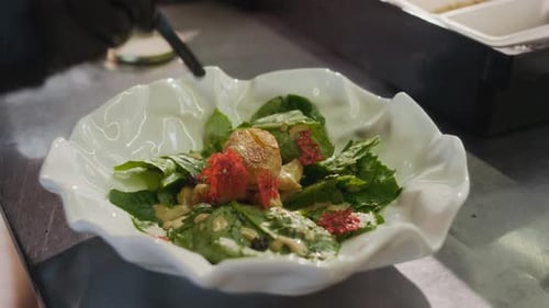 Closeup Chef Dotting Sauce and Caviar Onto Scallop Seafood Dish in Restaurant