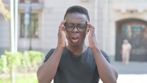 Young Adult Experiencing a Headache Outdoors