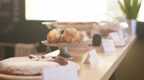 Organic backing goods presented on platter food stands on a counter in a restaurant with cakes and m