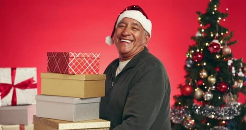Christmas, gift and face of old man in studio for happy, holiday season and festive celebration