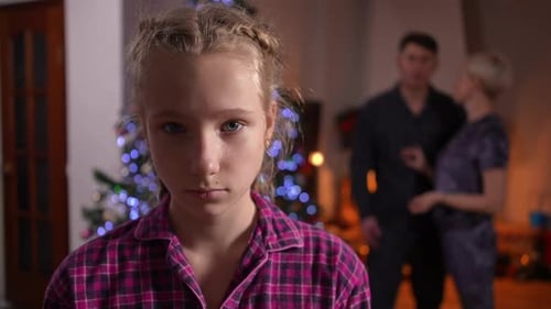 Closeup Front View of Sad Dissatisfied Teen Girl Posing in Living Room on Christmas with Blurred
