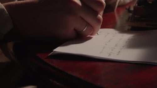 Writer Takes Notes on a Paper in a Dark Room at Night
