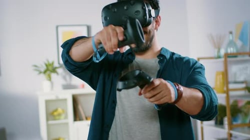 Enthusiastic Man Using Virtual Reality Headset and Controllers