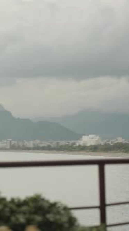 A young woman in a restaurant on a cliff in the sea, looking thoughtfully and fiddling with a napkin