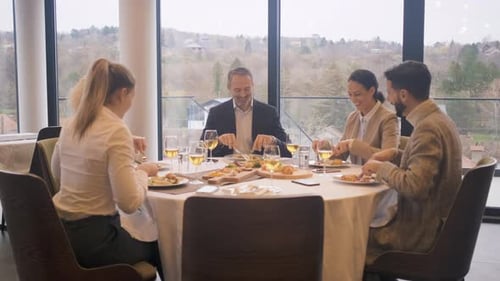 Smiling coworkers in restaurant talking during business lunch.