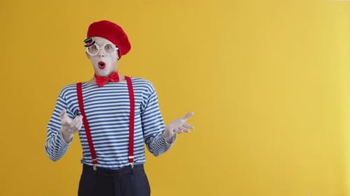 Der junge Pantomime-Typ ist sehr überrascht und wirft seine Hände hoch und zeigt mit dem Finger zur Seite