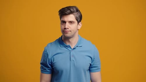 Man Talking and Gesturing in Front of an Orange Background