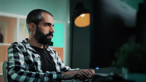 Handsome Caucasian employee or freelancer working from home sitting behind a desk developing a proje