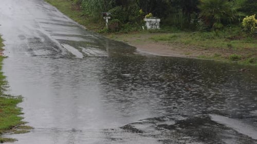 Rain Drenches Suburban Street, Causing Flooding