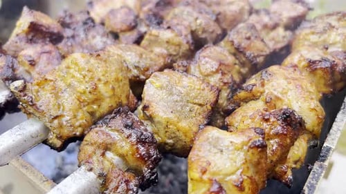 Close Up of Delicious Meat Cooking on Skewers
