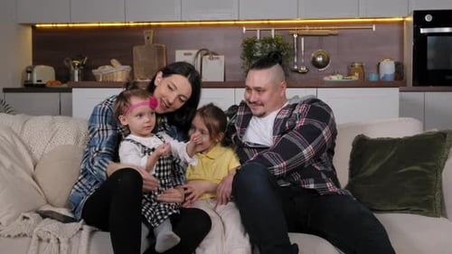 Happy Family Sitting Together on Couch at Home