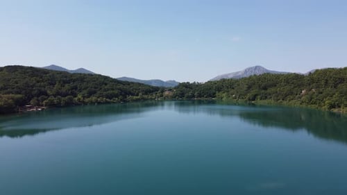 Immerse in the serenity of a tranquil lake, surrounded by lush greenery. Still waters of the lake r
