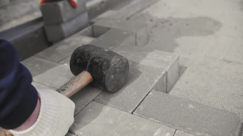 Builder Lays Paving Stones on the Street