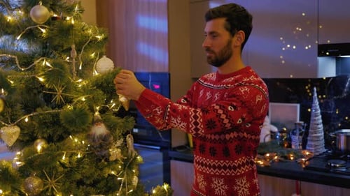 Man Decorates Christmas Tree in Cozy Home Setting