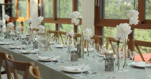 A Table with White Flowers is Decorated for a Festive Dinner
