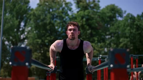Muscular Man Doing Dips at Outdoor Gym