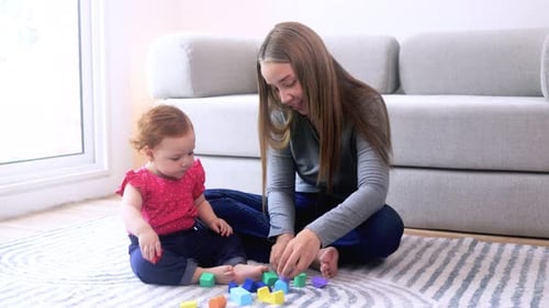 Mother and Baby Playing with Colorful Building Blocks