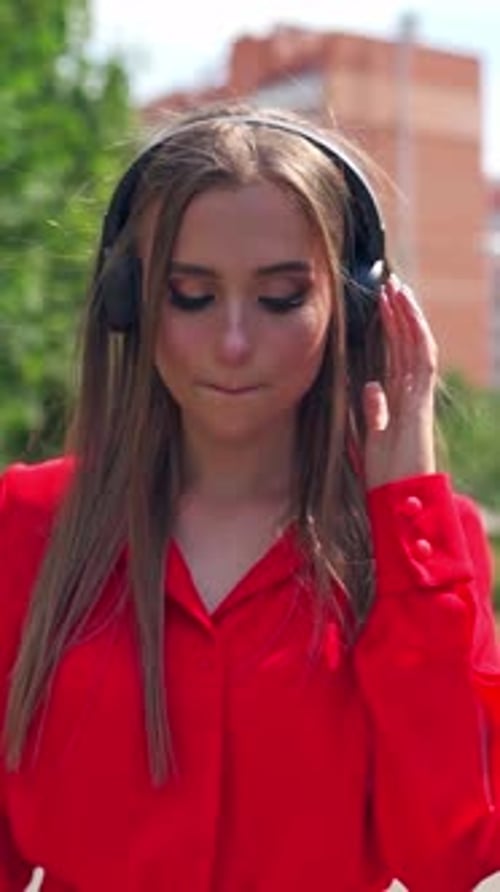 Young Woman Listening to Music with Headphones Outdoors