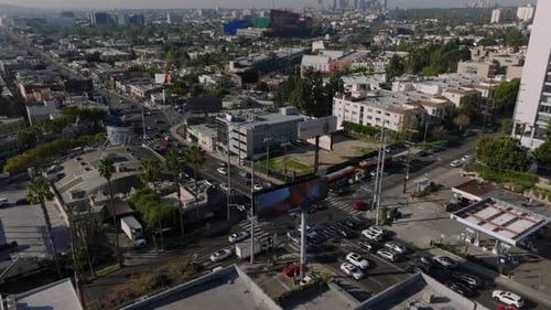 High Angle View of Vehicles Passing Through Road Intersection Tilt Up Reveal Cityscape with