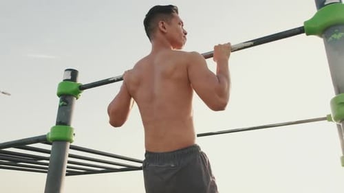 Fit Man Doing Pull-Ups Outdoors