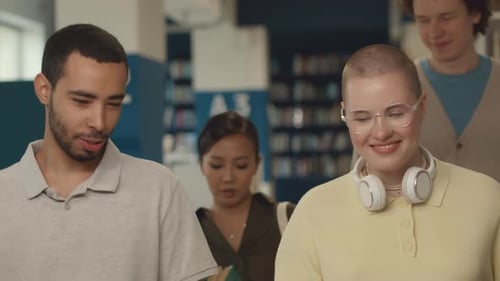 Group of Multiethnic Students Walking Together through Library
