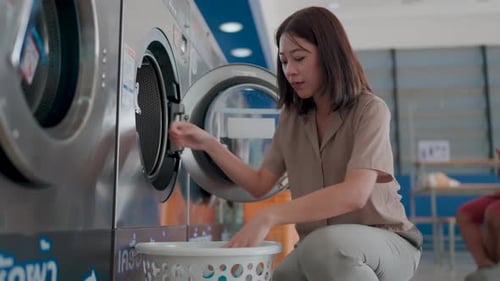 Woman Puts Laundry in a Washing Machine