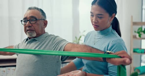 Senior Man Stretches Resistance Band with Trainer