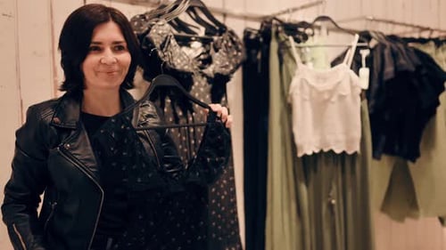 Mulher atraente experimenta um vestido em uma loja de roupas de shopping center